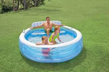 padre con sus niños en piscina hinchable